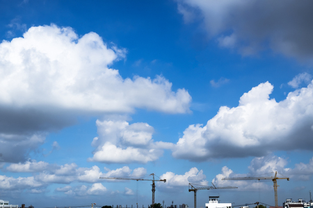 Beautiful cloudy skyscape of the city with buildings and cranes.の写真素材