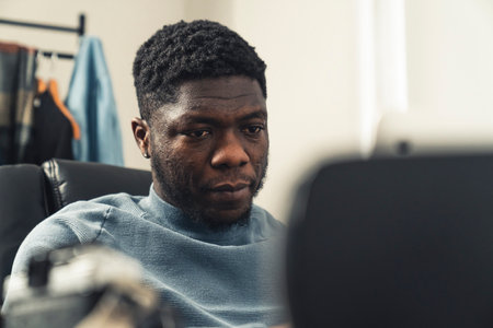 Focused black man working in home on tablet pc - close up shot. High quality photoの写真素材