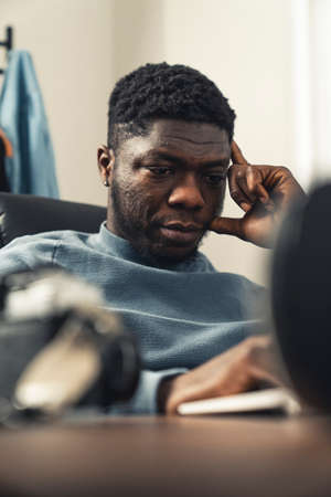 Thinking black man working on laptop computer - portrait shot. High quality photoの写真素材