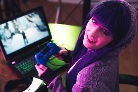 Caucasian woman playing computer games and looking into the camera medium close-up shot. High quality photoの写真素材