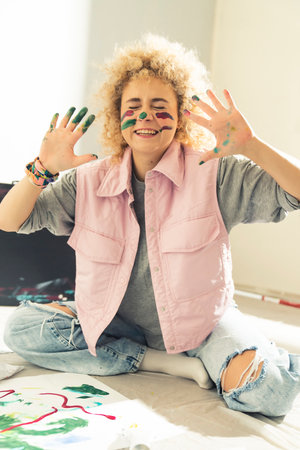 Happy young Artist playing and Putting Colors On Her nose Using Finger. Childhood concept. High quality photoの写真素材