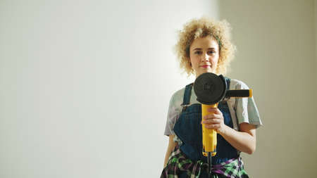 Student girl holding a disc angle grinder - work opportunities for students. High quality photoの写真素材