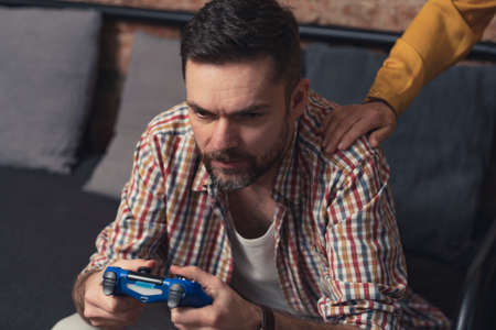 caucasian addicted gamer escapes from reality and his relatives by playing computer games all the time. High quality photoの写真素材