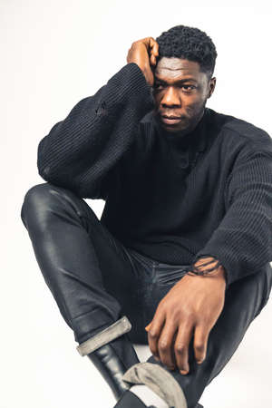 Pensive worried black men sitting hand in the head white background - full shot. High-quality photoの写真素材
