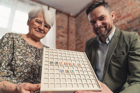 Mothers Day Celebration By Caucasian Grey-Haired Woman and Her Millennial Son. High quality photoの写真素材