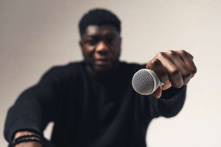 person of color holding exhibiting microphone studio - close up shot. High-quality photoの写真素材