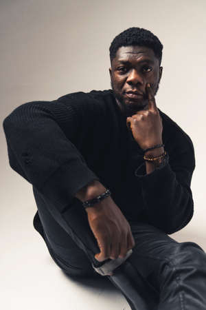 man of color making eyelid pull expression sitting - portrait shot. High-quality photoの写真素材