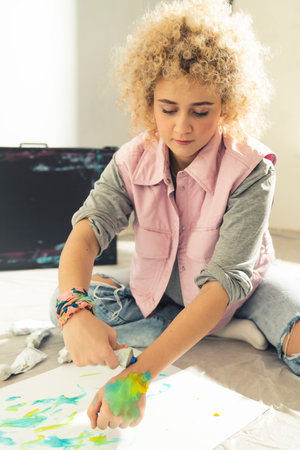 Attractive Caucasian female art student cought mixing tempera during painting classes. High quality photoの写真素材