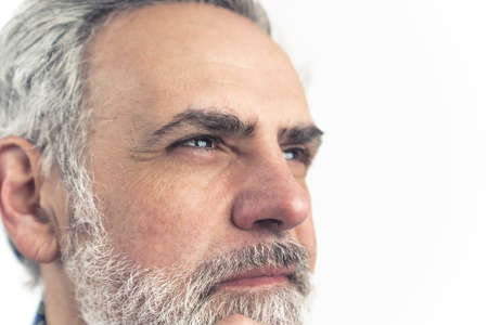Confident man in middle-age with gray hair and beard contemplating - extreme close up. High quality photoの写真素材