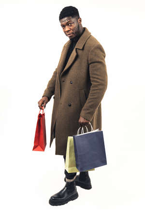 black male shopper with bags in his hands white background - full shot. High quality photoの写真素材
