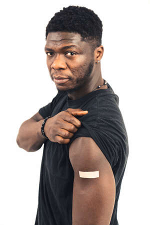 African vaccinated showing arm looking camera white background - portrait shot. High quality photoの写真素材