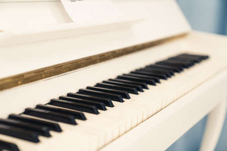 closeup photo of an elegant white piano standing indoors. High quality photoの写真素材