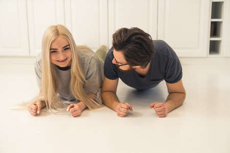 content happy European couple doing plank pose, practicing yoga, and caring about their mental and physical health. High quality photoの写真素材