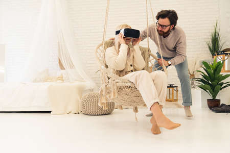 blond caucasian middle-aged woman fascinated with VR technology that her bearded husband showed her. High quality photoの写真素材