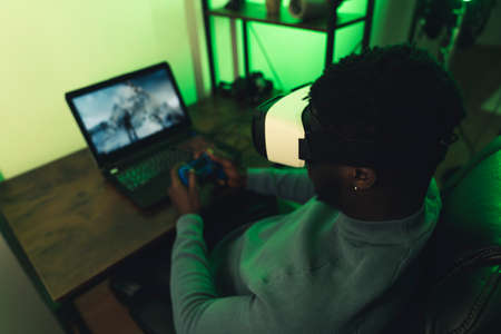 African American man playing in his room with VR headset - full shot . High quality photoの写真素材