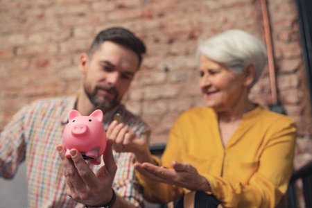caucasian businessman surprised by the way his elderly mother saves her money. High quality photoの写真素材