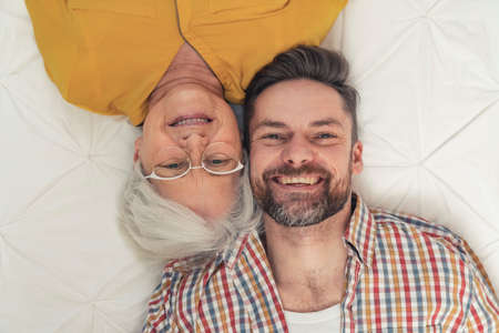 generational difference between grinning elderly grandma and her content middle-aged son. High quality photoの写真素材