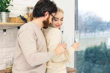 beautiful caucasian long-haired girl flirts with her new boyfriend while holding white wine glasses medium shot. High quality photoの写真素材