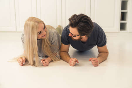 lovely caucasian couple in a plank pose exercising in their modern apartment during self-care routine. High quality photoの写真素材
