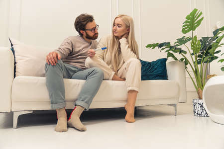 young couple worried about the results of pregnancy test, looking at each other with a concerned look. High quality photoの写真素材