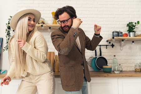 Happy caucasian couple having fun and dancing together in modern kitchen. High quality photoの写真素材