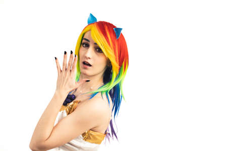 Young woman with rainbow hair turns and looks shocked into the camera medium studio shot white background. High quality photoの写真素材