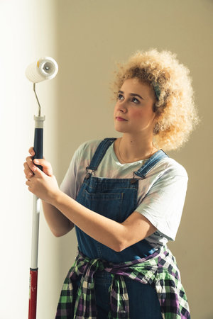 beautiful caucasian woman smiling posing with paint roller - portrait. High quality photoの写真素材