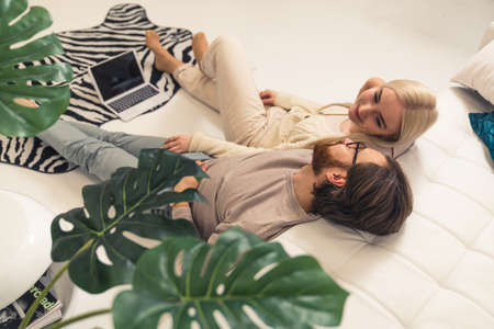 content caucasian couple celebrating Valentines Day laying on the floor, looking at each other, and smiling. High quality photoの写真素材