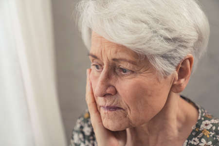 portrait of an elderly pensioner woman suffering from dementia and being depressed close up shot. High quality photoの写真素材