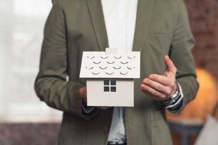 advertisement entrepreneur developer presenting mini plastic house . High quality photoの写真素材