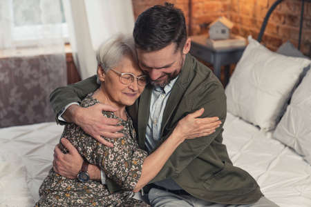 cheerful relatives grandmother and her oldest grandson cuddling and celebrating Grandparents Day. High quality photoの写真素材