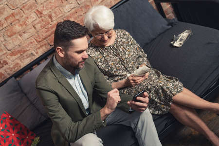 caucasian relatives with generation gap talking about changing photography smartphone photography vs. printed photographs . High quality photoの写真素材