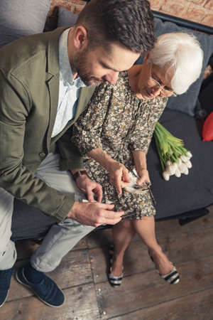 A little bit of memories with elderly grandmother and her adult grandson vertical shot. High quality photoの写真素材