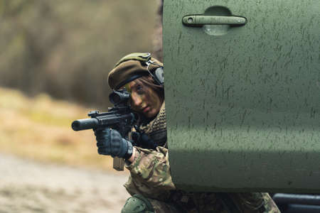 Nasty feminine soldier focusing on target hiding. High quality photoの写真素材