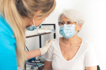 Young nurse cheering up elderly grandmother during mostly checkup. Safe and healthy retirement. High quality photoの写真素材