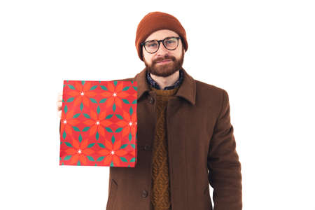Portrait of young attractive Caucasian bearded man smiling and showing red floral bag to the camera...
