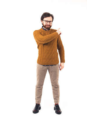 Confident young Caucasian man standing and smiling, pointing his finger backwards direction encouragement concept advertising full shot white background isolated studio shot copy space . High quality photoの写真素材