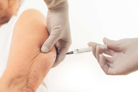 Caucasian persons arm. Getting vaccinated agains virus or other diseases concept. White background, studio shot. High quality photoの写真素材