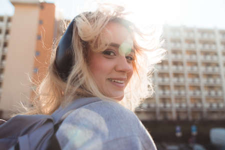 Portrait of a youthful European teenage girl wearing old-school headphones and looking at camera...