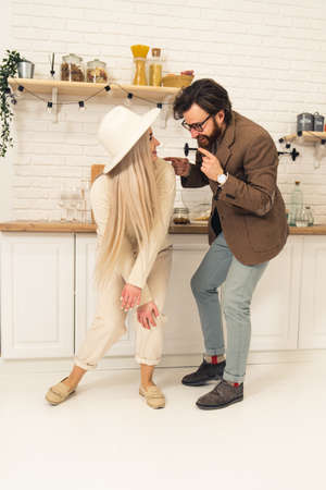 Young Caucasian married people dancing in the kitchen looking at each other full shot . High quality photoの写真素材