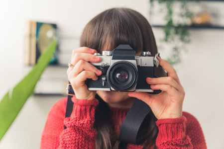 Dark haired European woman taking photo with a camera copy space medium closeup . High quality photoの写真素材