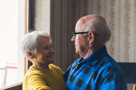 Portrait of happy caucasian senior couple dancing and smiling in their vintage living room. Active seniors concept. High quality photoの写真素材