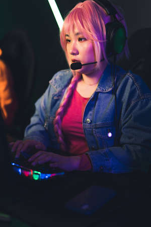 professional eSport gamer girl streaming and playing online video game on PC medium closeup indoors online games concept . High quality photoの写真素材