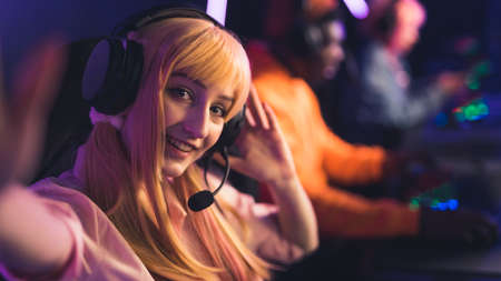 Selfie of young Caucasian female player in a wig and headphones smiling copy space players on the...