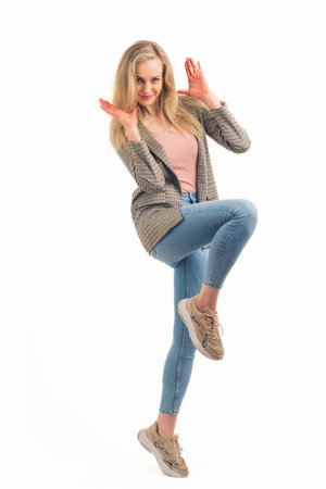 surprised beautiful European blonde girl smiling into the camera full shot studio shot white background copy space. High quality photoの写真素材