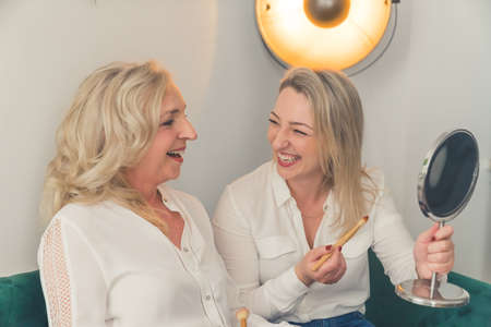Smiling millennial girl child with overjoyed funny elderly mother at home, happy grown-up adult daughter have fun making up with mom, relax together on weekend. High quality photoの写真素材