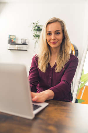 Portrait of a beautiful woman sitting by the table in front of the laptop remote job concept copy...
