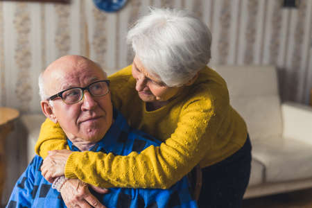 positive Cuacasian grandparents having fun and enjoying together at home medium closeup senior...
