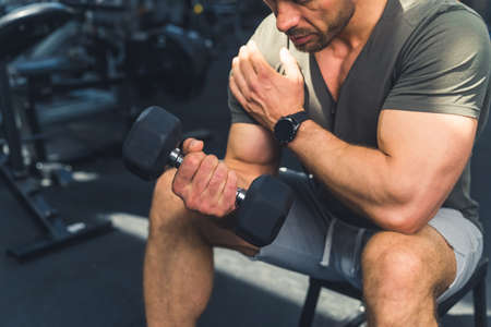 Working on his arms. Cropped shot of a muscular young man working out in the gym. High quality photo