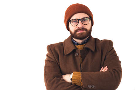 Portrait of a fashion company bearded male CEO in brown autumn outwear with crossed arms looking straight to the camera over white background. High quality photoの写真素材